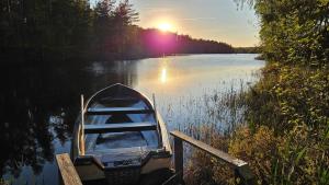a small boat parked at a dock on a lake at Björklunda, lakes, canoe, sauna in Näfstorp