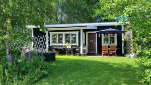 a small house with an umbrella in a yard at Björklunda, lakes, canoe, sauna in Näfstorp