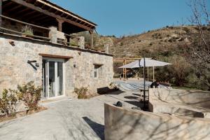 a person sitting under an umbrella next to a building at Casa del Bienestar in Lanjarón
