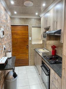 a kitchen with a stove and a wooden door at 26 Rubens apartments in Secunda