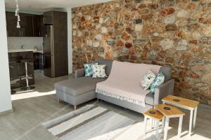 a living room with a couch and a stone wall at Casa del Bienestar in Lanjarón