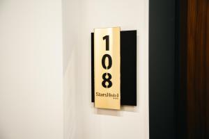 a black and white clock on a white door at Stars Hotel in Jelah +78 photos