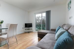 a living room with a couch and a table at Charming 1Bed Flat with Private Balcony, Super Double Bed, Free Allocated Parking, and Easy Access to Tube & Central London in Enfield