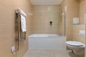 a bathroom with a tub and a toilet at Charming 1Bed Flat with Private Balcony, Super Double Bed, Free Allocated Parking, and Easy Access to Tube & Central London in Enfield