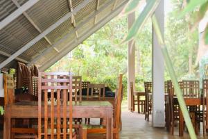 a dining room with wooden tables and chairs at Kadulla Resort in Habarana