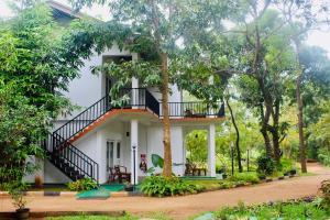 a white house with a staircase in front of it at Kadulla Resort in Habarana