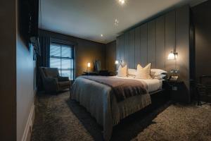 a hotel room with a large bed and a chair at Dakota Edinburgh in Queensferry