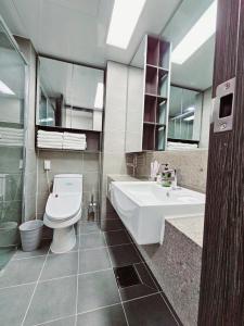a bathroom with a toilet and a tub and a sink at We -Ciel de Mer in Busan