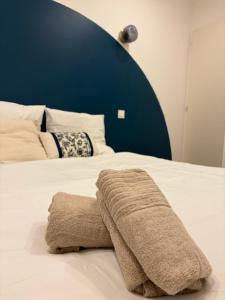 a bed with a towel on top of it at Charmant Appartement Moderne B in La Roche-sur-Yon