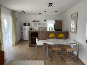 a kitchen with a white table and yellow chairs at Angyalkert in Balatonszárszó