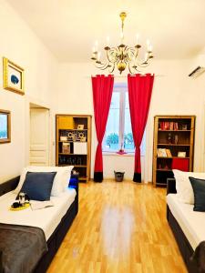 a living room with two beds and red curtains at Agora Apartments -Friend's House Sorrento in Sorrento