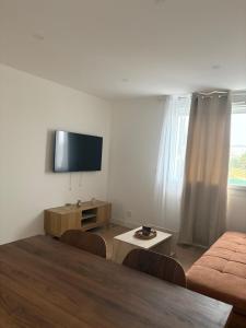 a living room with a flat screen tv and a couch at Charmant Appartement Moderne B in La Roche-sur-Yon