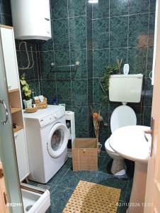 a bathroom with a toilet and a washing machine at Apartman Vuk in Obrenovac +17 photos