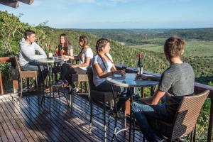 a group of people sitting at tables on a deck at Kariega Game Reserve Main Lodge in Kenton on Sea