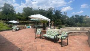 a patio with chairs and a table and an umbrella at Independent accommodation on Etna in San Giovanni Montebello