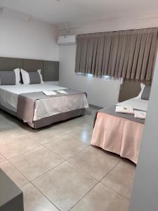 a bedroom with two beds and a tile floor at Mimari Hotel in Tangara da Serra