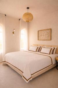 a large white bed in a bedroom with a chandelier at Villa Riad- וילה ריאד מתחם נופש יוקרתי in Migdal +50 photos