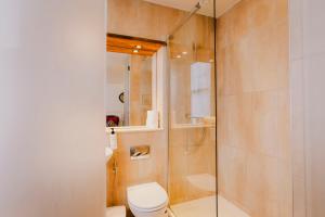 a bathroom with a toilet and a glass shower at The Galaxie in Oxford +57 photos