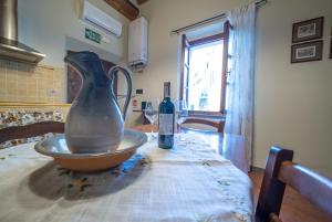 a vase and a bottle of wine on a table at La casina di Zora in Lorenzana +33 photos