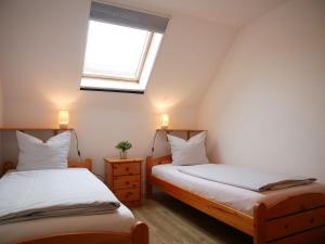 two twin beds in a room with a window at Robby2 in Kaltenhof