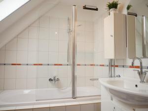 a white bathroom with a shower and a sink at Robby2 in Kaltenhof +20 photos