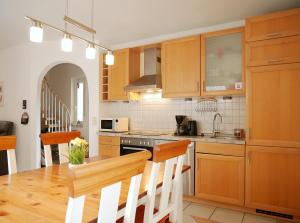 a kitchen with wooden cabinets and a table with chairs at Robby2 in Kaltenhof
