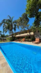 a blue swimming pool in front of a house at Pousada Recanto Itaguá in Ubatuba
