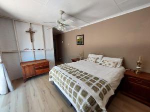 a bedroom with a bed and a cross on the wall at Raphas Eco Homestead in Bethulie