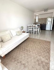 a living room with a white couch and a kitchen at R Haus 2 Con Cochera in Concordia
