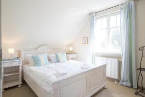 a white bed in a room with a window at Ferienhaus Werder in Zingst in Zingst