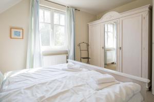 a white bed in a room with a large window at Ferienhaus Werder in Zingst in Zingst