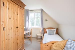 a small bedroom with a bed and a window at Ferienhaus Werder in Zingst in Zingst +4 photos
