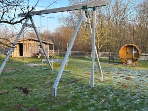 an empty swing set in a yard with a shed at Ferienhaus Tutsch Ostblick in Wangels
