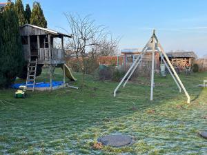 a playground with a slide and a play house at Ferienhaus Tutsch Ostblick in Wangels