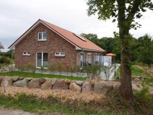 a brick house with a rock wall in front of it at Ferienhaus Tutsch Westblick in Wangels