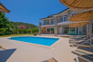 eine Villa mit Swimmingpool und einem Haus in der Unterkunft Villa Brezza in Fethiye