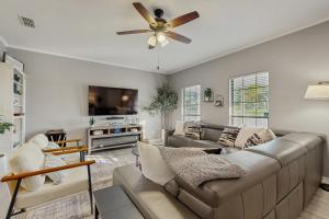 a living room with a couch and a ceiling fan at Stunning Rivrefront 3BR with Hot tub, water view! in Seguin