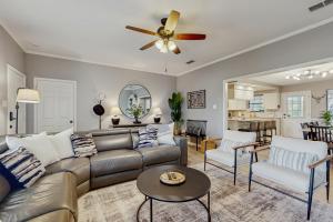 a living room with a couch and a ceiling fan at Stunning Rivrefront 3BR with Hot tub, water view! in Seguin