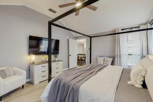 a bedroom with a bed and a flat screen tv at Stunning Rivrefront 3BR with Hot tub, water view! in Seguin