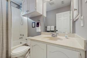 a white bathroom with a sink and a toilet at Stunning Rivrefront 3BR with Hot tub, water view! in Seguin +35 photos