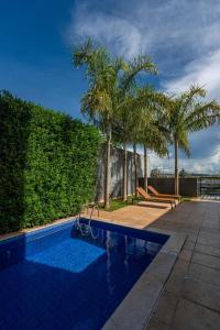 ein Swimmingpool mit Palmen neben einem Ferienresort in der Unterkunft Catuai Hotel Cacoal in Cacoal
