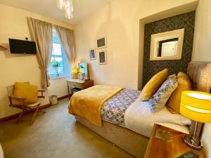 a bedroom with a bed and a desk and a chair at Glendale Guest House in Penrith