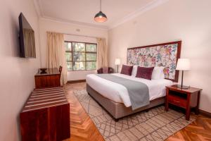 a bedroom with a large bed and a window at Bronte Hotel in Harare