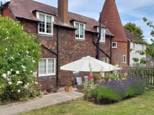 a house with an umbrella and flowers in front of it at 2 Bed in Biddenden oc-cb616 in Biddenden