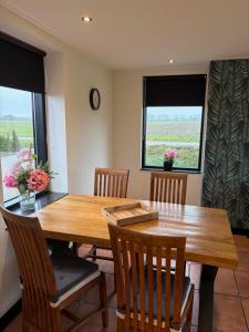a dining room with a wooden table and chairs at De Danser 2 in Klaaswaal