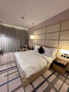 a bedroom with a large white bed and a couch at 7Crown Tahliah Hotel in Riyadh