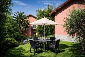 a table and chairs with an umbrella in a yard at Hotel Del Borgo in Sestri Levante