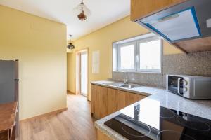 a kitchen with a sink and a microwave at Casa Fermil da Graça in Veade