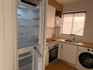 a kitchen with an empty refrigerator and a sink at Azores Pedra Apartaments A in Fajã de Baixo