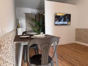 a dining room table with two chairs and a television on the wall at Azores Pedra Apartaments A in Fajã de Baixo +7 photos